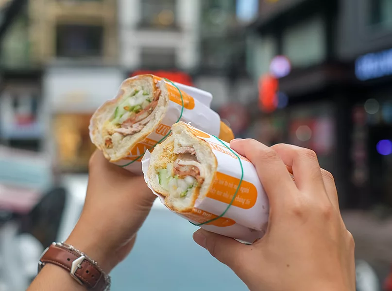 A woman holding Banh Mi, Vietnamese Sandwich